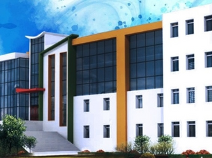 Modern building with white walls, large glass windows, and colorful accents. Green lawn and trees in foreground under a blue sky.