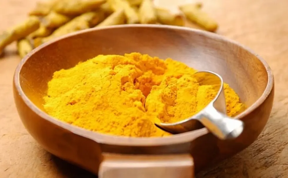 Thumbnail: Turmeric powder in a wooden bowl with a spoon; spices in the background.