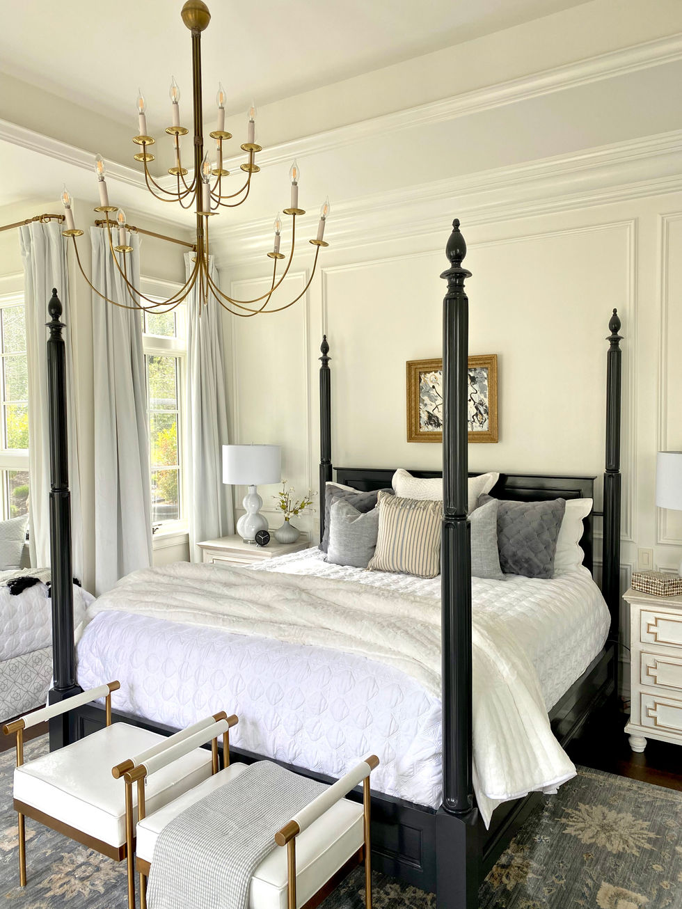 Four poster bed in elegant master bedroom design with art and brass chandelier.