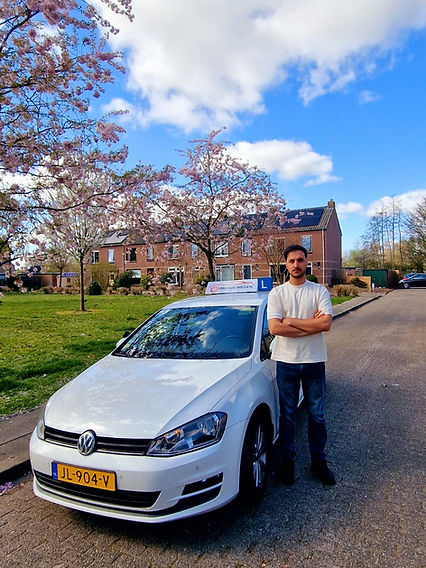 Rijinstructeur naast lesauto van Oranje Wielen in Amersfoort