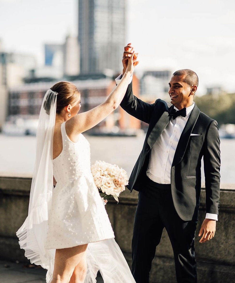 London wedding by the Themes. Groom in tux and bride in mini dress with veil.