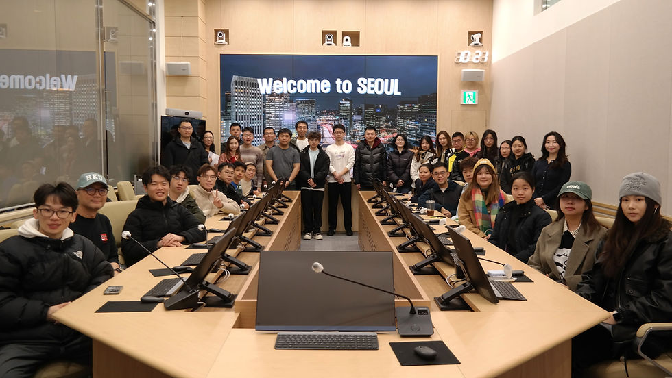 Group of people posing in a conference room with computers, in front of a screen reading Welcome to SEOUL.