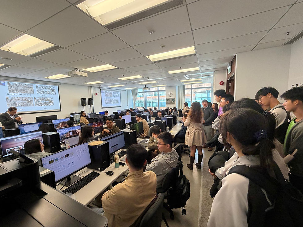 Students and instructors in a computer lab, watching slides on bits while seated among rows of desktop PCs.