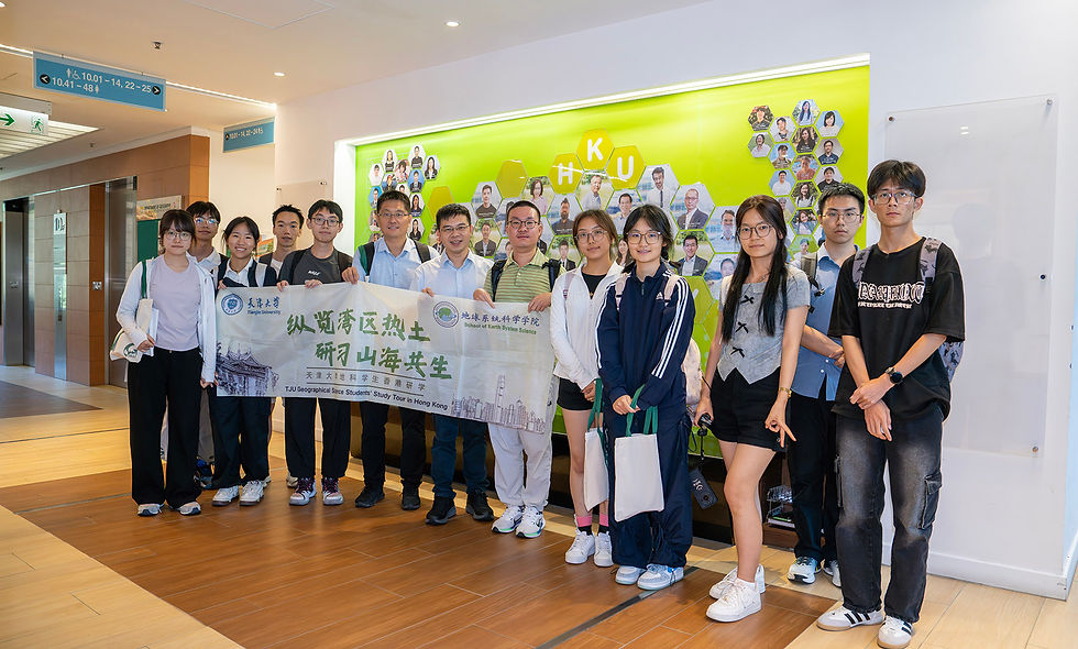 Group of students and teachers pose indoors holding a banner for TUJ Geographical Science Students' Study Tour in Hong Kong.