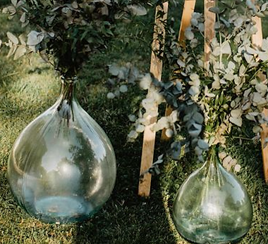 Dames-jeannes en verre avec feuillage, décoration de mariage bohème à Montpellier Occitanie.
