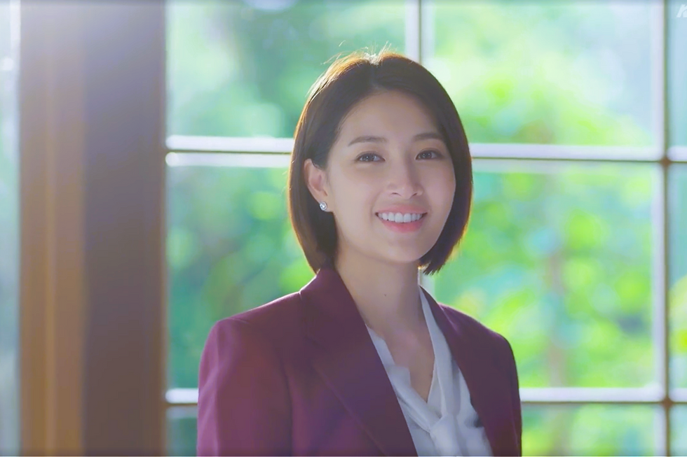 Mudmee stands inside the new café, smiling softly as she sees Khanrin walk through the door in Chasing Love EP2.