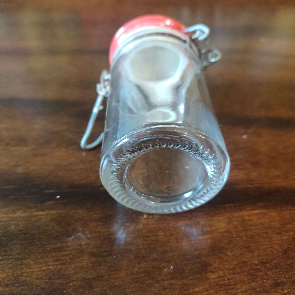 Vintage glass spice jar with metal closing and red top