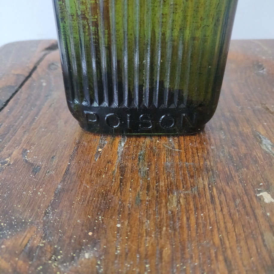 Antique early 20th century green ribbed poison bottle with original stopper/lid