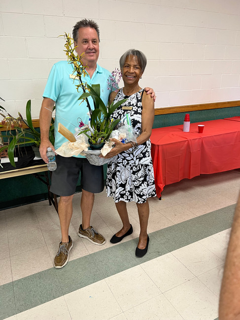 Juanita Soriana and Scott Bartlett taking a picture with the TOC raffle basket she won at the May luncheon