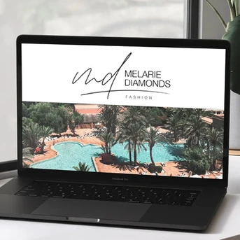 Website design for Melarie Diamonds Fashion displayed on a MacBook Pro, featuring a handwritten-style logo and a tropical resort background to convey luxury and elegance