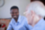 Carer and older gentleman conversing and smiling