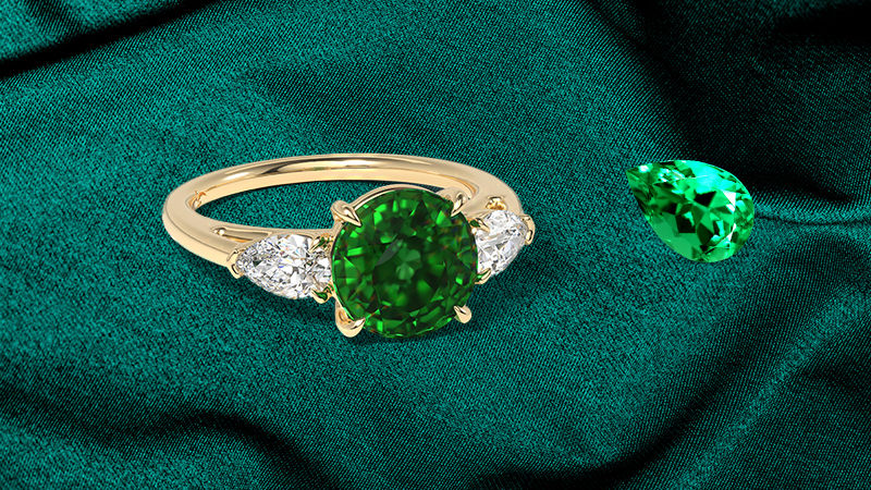 A beautifully crafted emerald engagement ring set in a background of a textured dark stone