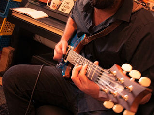 מורה לגיטרה מעביר שיעור אישי באווירה חמה בסטודיו מוזיקלי בצפון