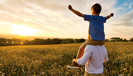 Box on father's shoulders looking at sunset