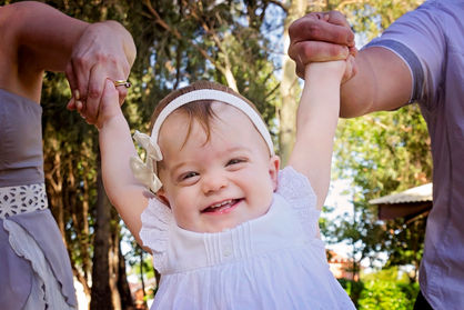 baby swung between parents photo