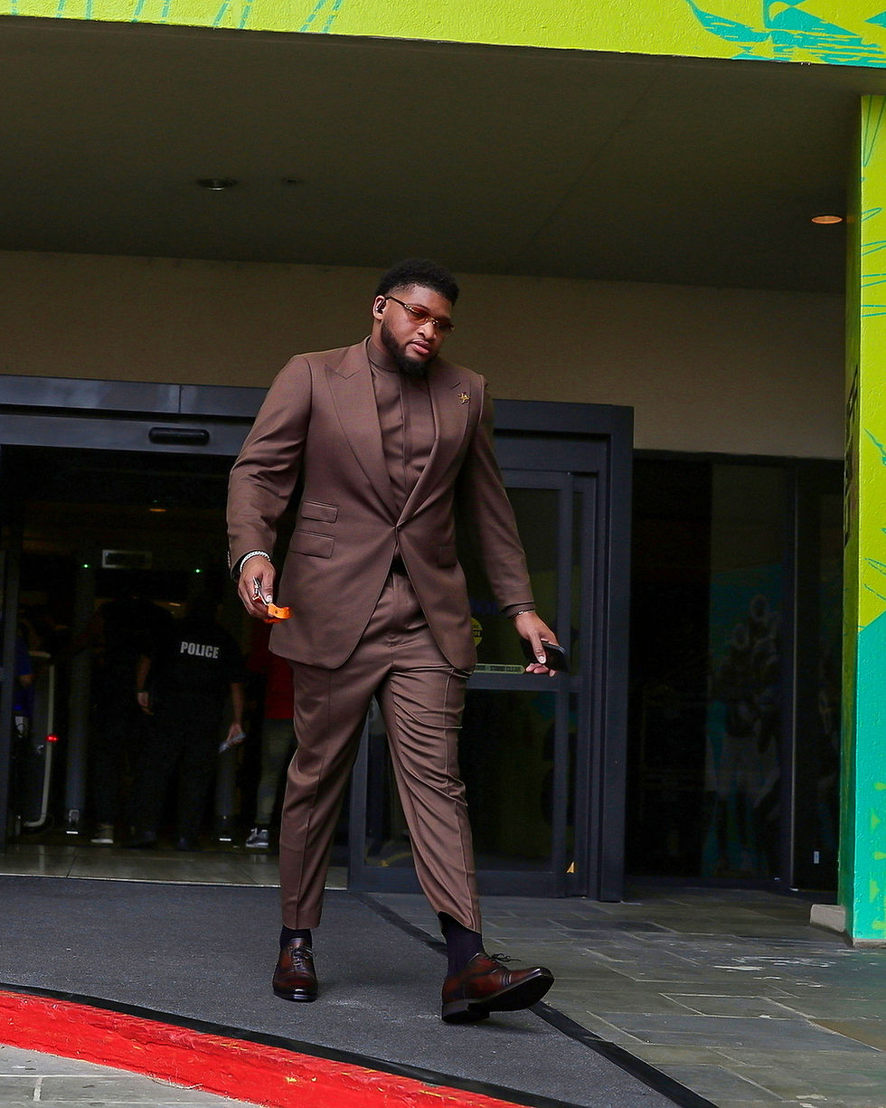 Fred Johnson walks outside of the Superdome in an all-brown suit ahead of Super Bowl LIX.