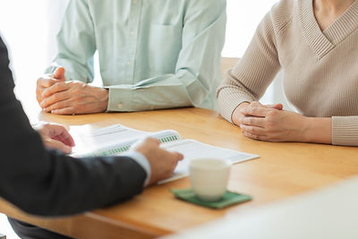 中年夫婦に説明するビジネスマン