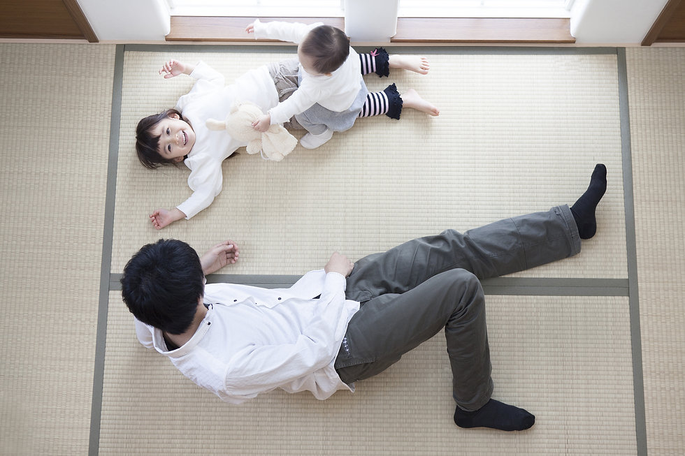 畳の上に寝転ぶ家族