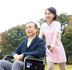 高齢の男性と車いすを押す女性