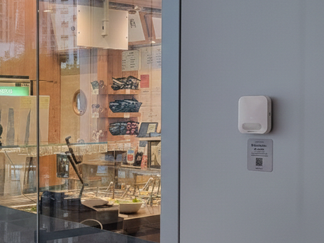 an indoor air quality sensor installed on the wall of a commercial building