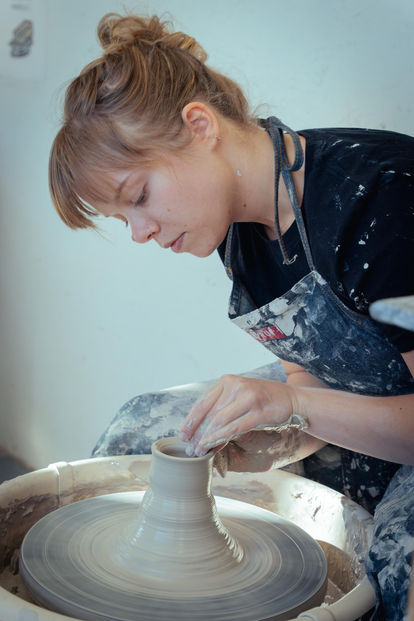 Ceramic artist member working on pottery wheel