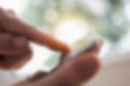 A close-up of hands scrolling through a phone.