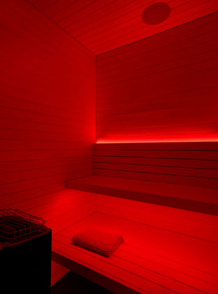 A residential sauna lined with RGBW lighting that glows red