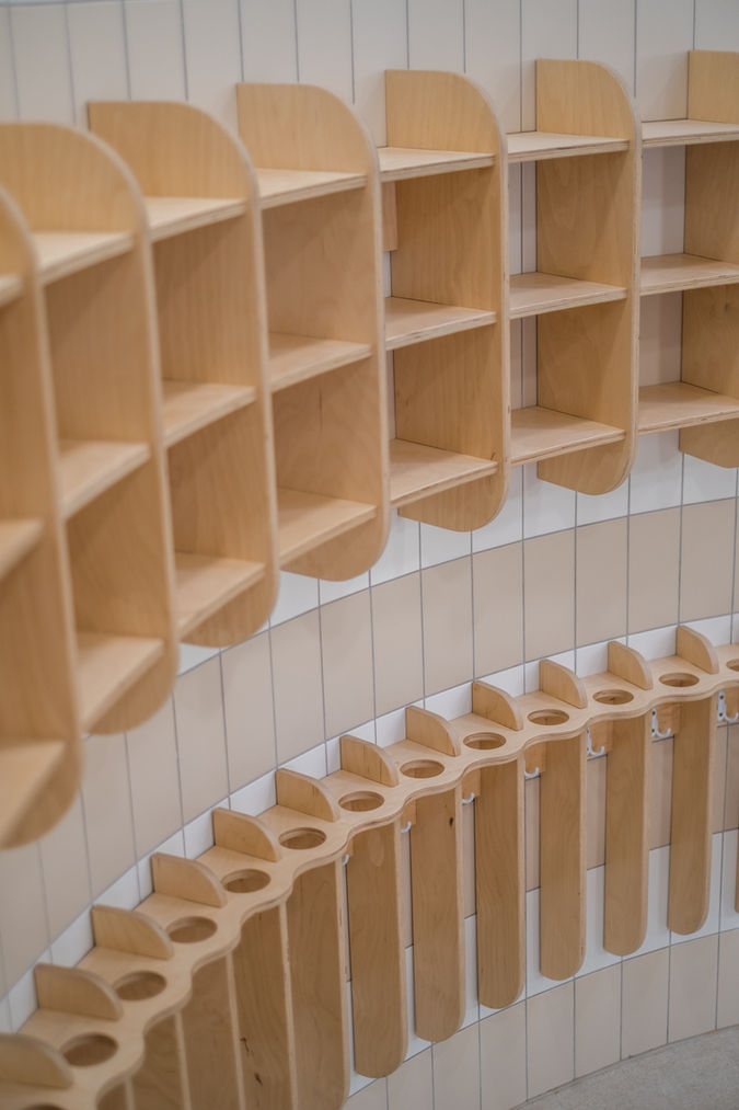 Visszafogott színű nyír rétegeltlemezből készült fali polcok fogmosópoharak és törölközők tárolására.