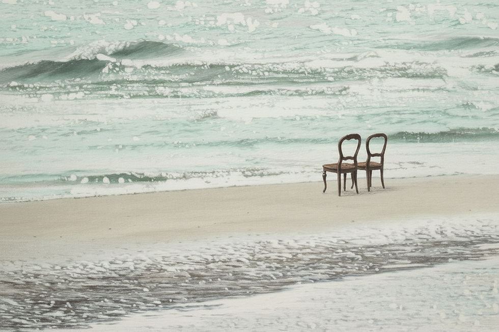 Imagem de duas cadeiras vazias na beira da praia