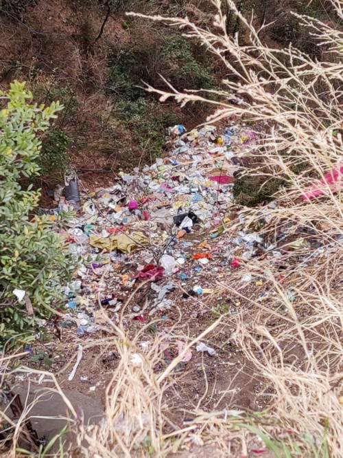 Garbage littered at the foot of the cliff