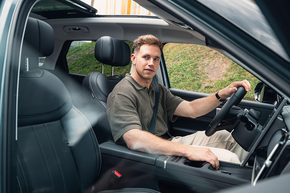 Harrie Lavreysen in een Jaecoo 7. Binnenkant auto met zwarte lederen stoelen.