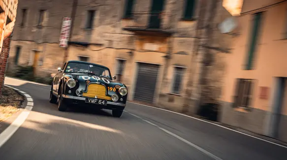 Klassieke rallyauto in Italiaans dorpsstraatje tijdens rally