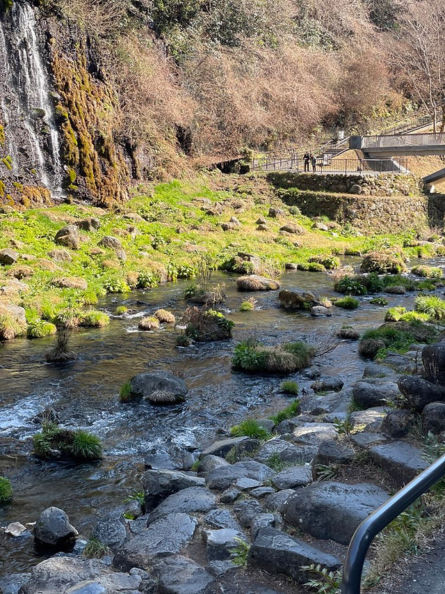 Ruhiger Fluss mit Wasserfall und Brücke