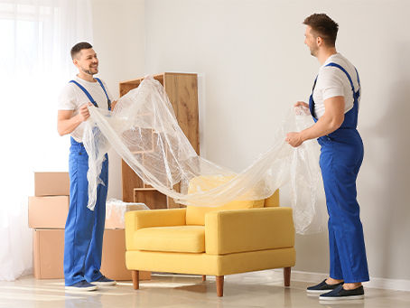 Professional movers wrapping furniture for safe transport