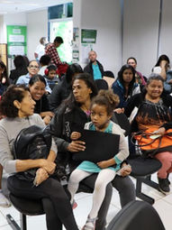 Sala com várias mulheres sentadas aguardando atendimento.