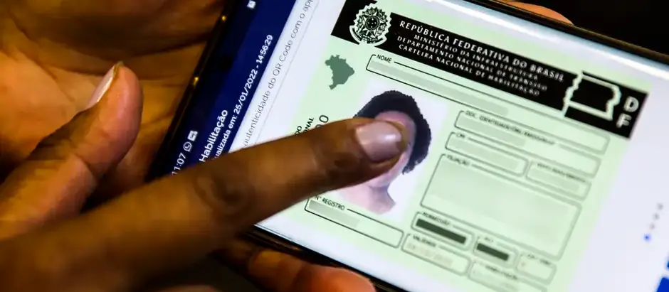 Mão passa por tela de celular com imagem da carteira digital de trânsito. O crédito é da Agência Brasil
