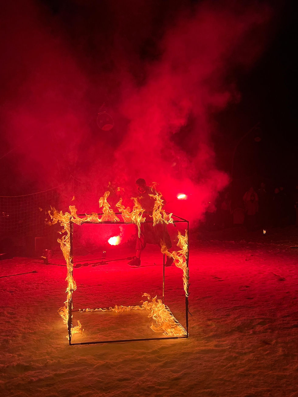 Cube en métal enflammé dans la neige, lumière rouge intense et fumée en arrière-plan. Ambiance dramatique et captivante.