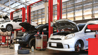 auto repair shop with cars on hydraulic lifts