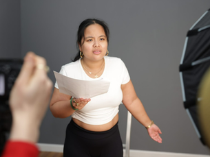 Woman performing a scene on camera while holding a script