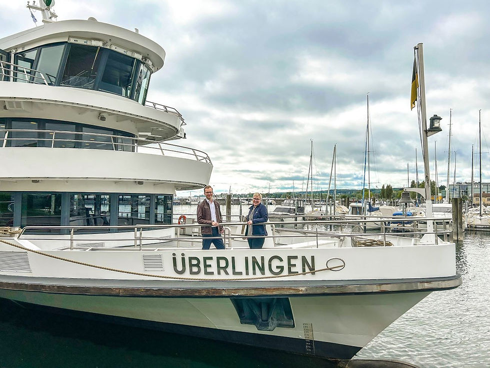 Ein Mann und eine Frau stehen auf einem Boot im See