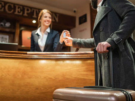 Eine Frau am Hotelempfang übergibt Zimmerschlüssel