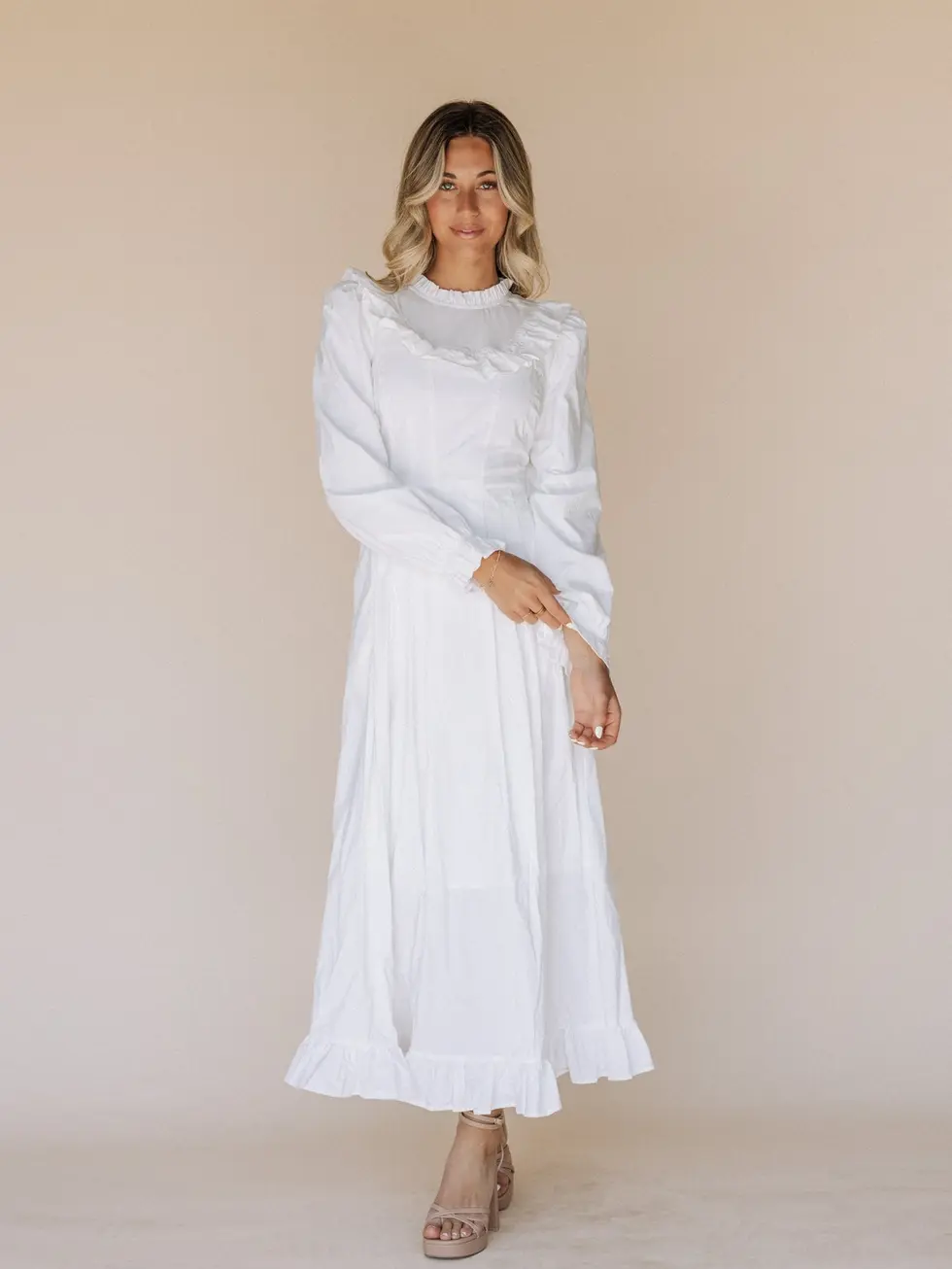 A woman wearing the Nauvoo LDS temple dress standing in a bright and serene setting