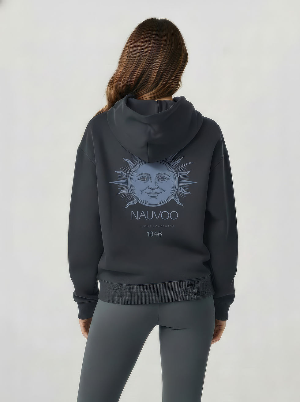 The back view of a woman wearing the Carbon Grey Nauvoo Sun christian hoodie, showcasing the detailed sunstone graphic and 'N