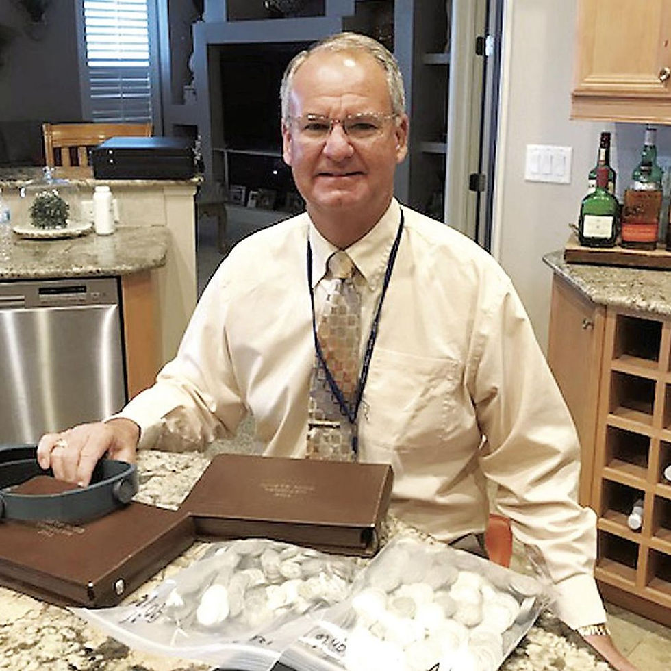 Man in a shirt and tie presenting jewelry boxes.
