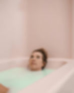 Young woman soaking quietly in a classic bathtub, illustrating the simpler, no-frills experience of a traditional bath compared to a whirlpool model.