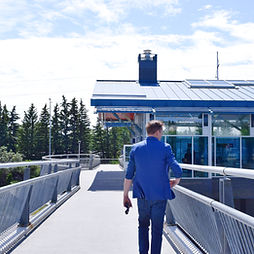 Dan Olesen walking toward a Calgary CTrain station, promoting sustainable transportation and accessibility