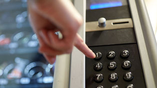 finger punching button on vending machine