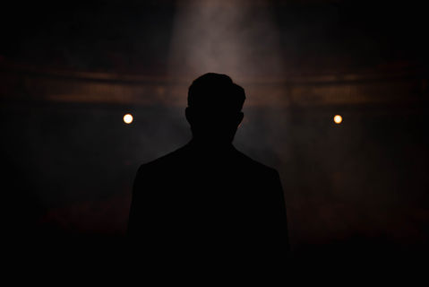 Silhouette dans la pénombre, Charles Miraskill incarne le mystère de “Secret”, un spectacle où l’ombre et la lumière révèlent l’art du mentalisme.