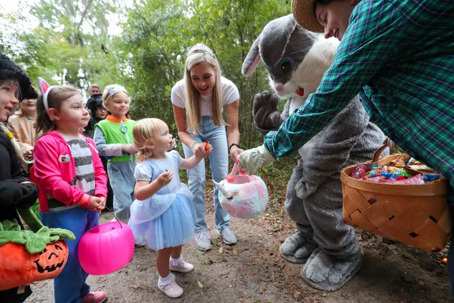 Trick or Treaters visit a bunny and get a piece of candy for their basket during the annual Oatland Island Halloween Hike on Friday, October 13, 2023. Richard Burkhart/Savannah Morning News