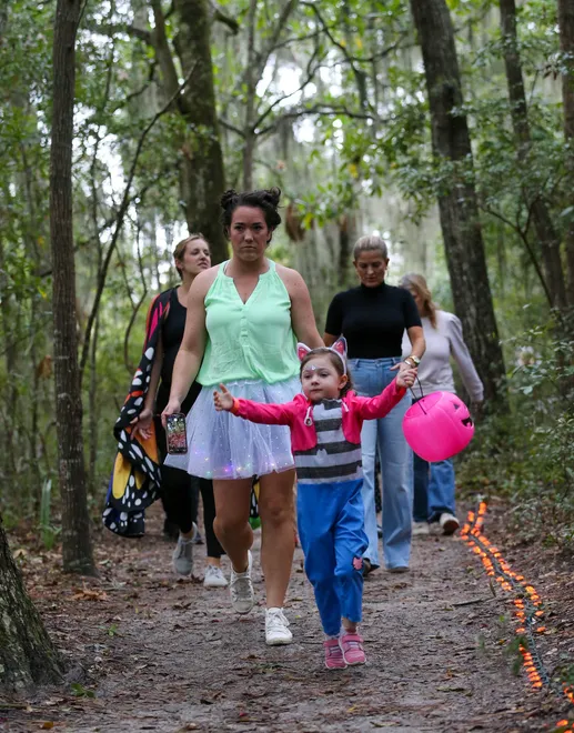 An excited trick or treater runs along the trail during the annual Oatland Island Halloween Hike on Friday, October 13, 2023. Richard Burkhart/Savannah Morning News